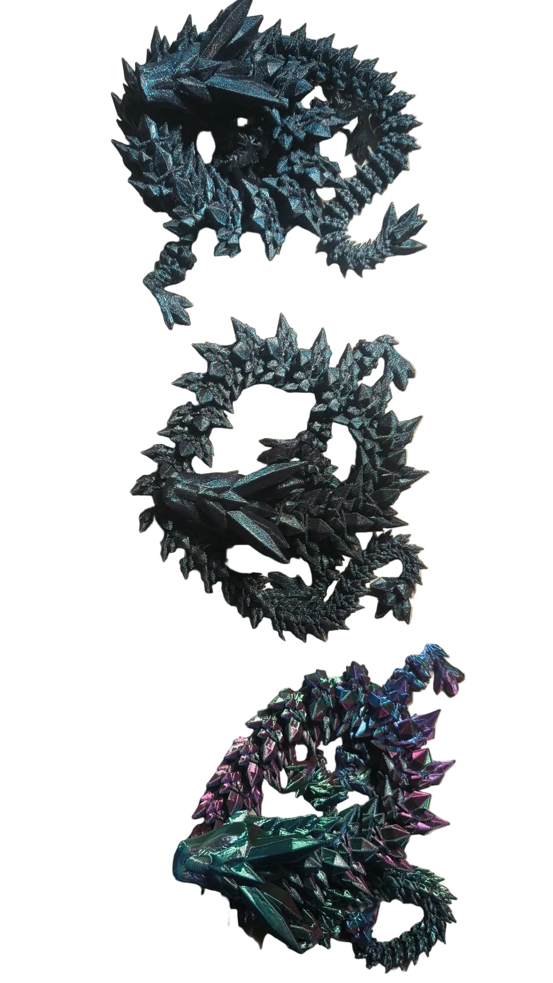 Three dragon figurines in different colors on a beige surface